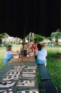 Looking down a long table at those eating the noon meal.